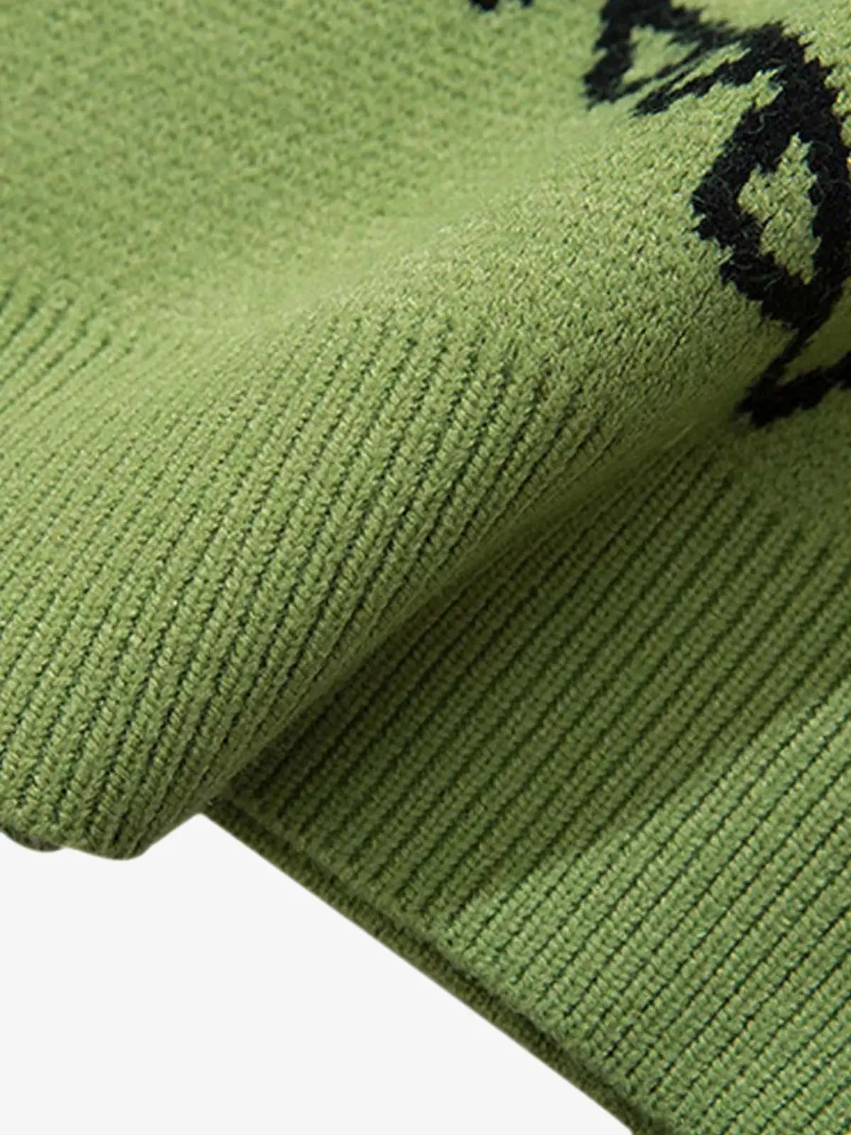 Flat lay of green dinosaur print sweater showcasing bold colourway