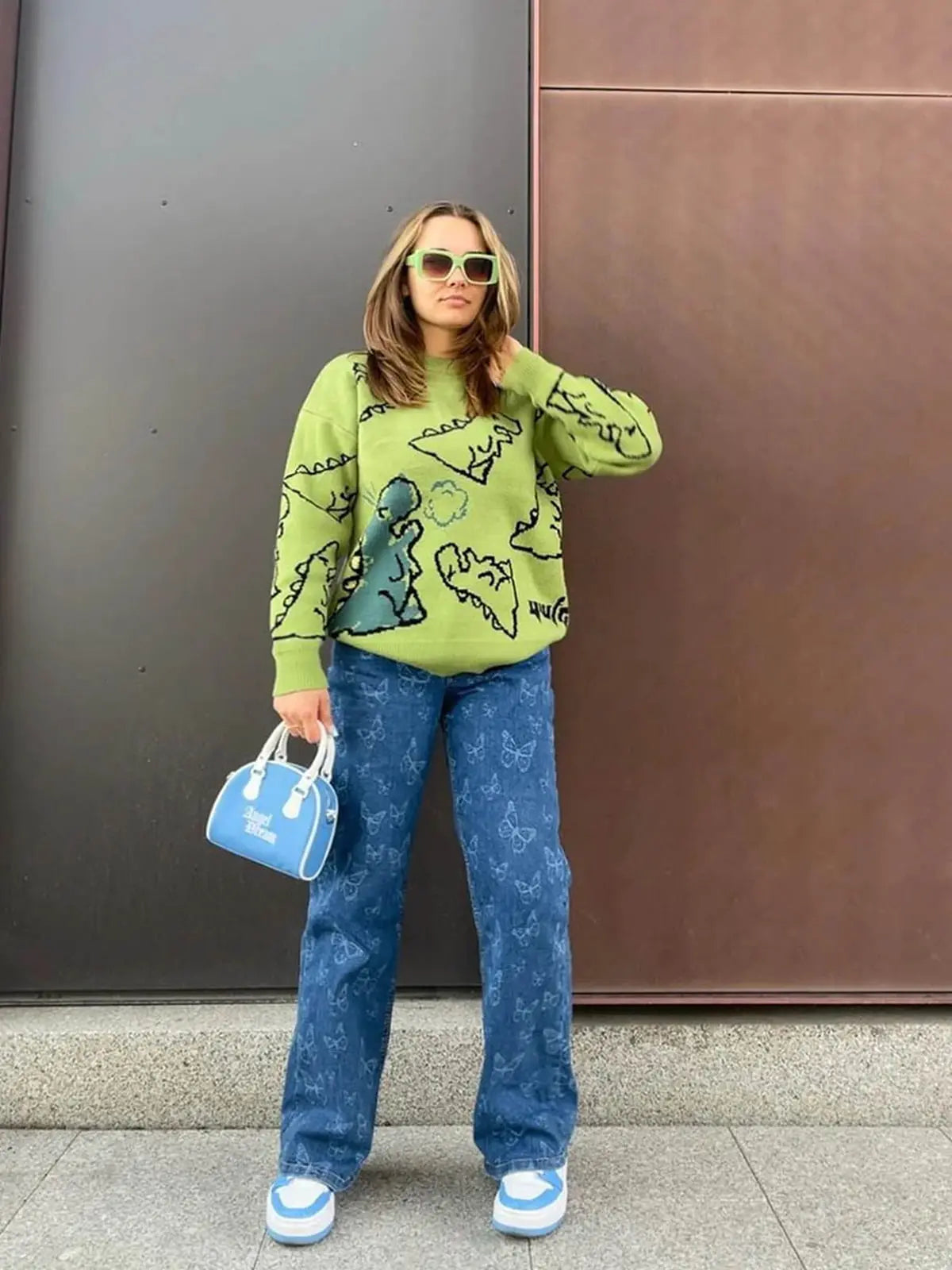 Model wearing green dinosaur print sweater for casual outfit inspiration