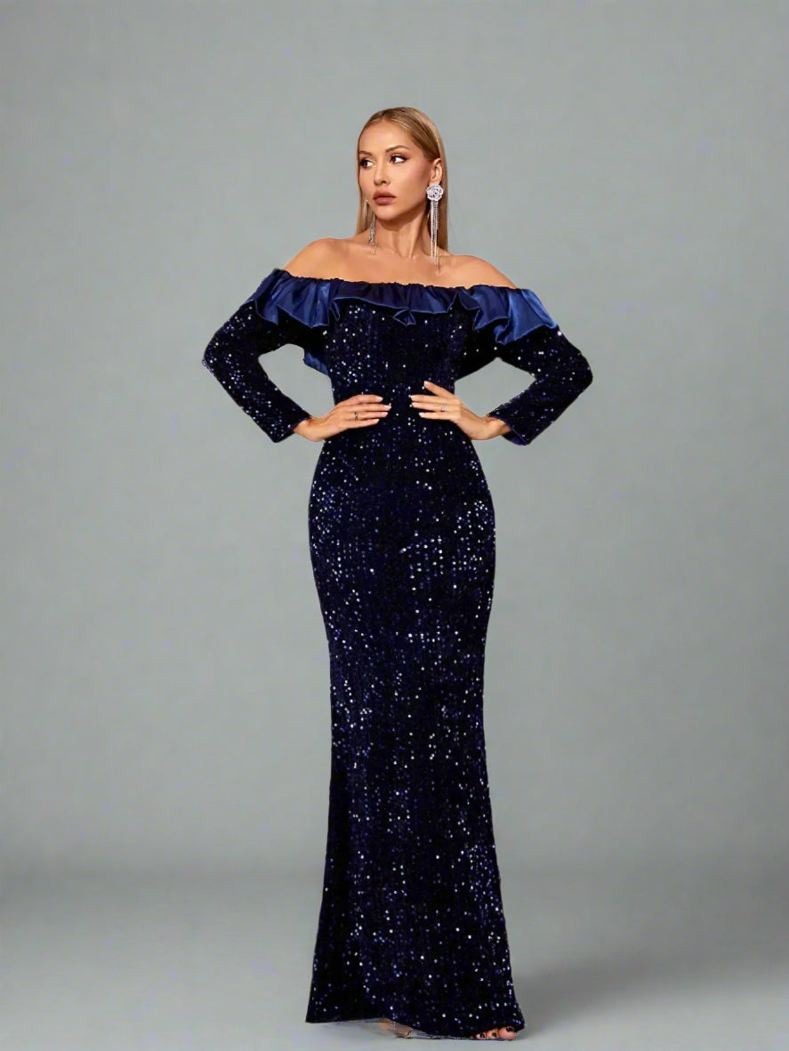 Front view of navy sequin off-shoulder gown with long sleeves and ruffle trim
